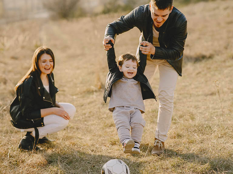 couple playing with child outside Agile Wealth